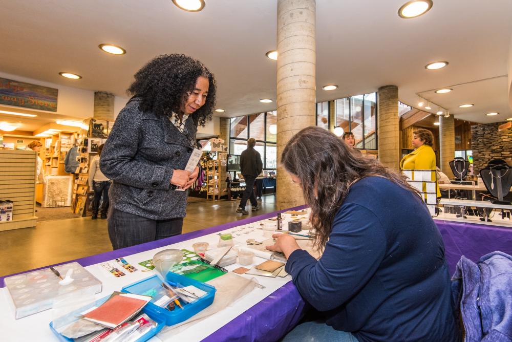 A woman enjoys a craft demonstration at the Folk Art Center on the Blue Ridge Parkway in Asheville, NC