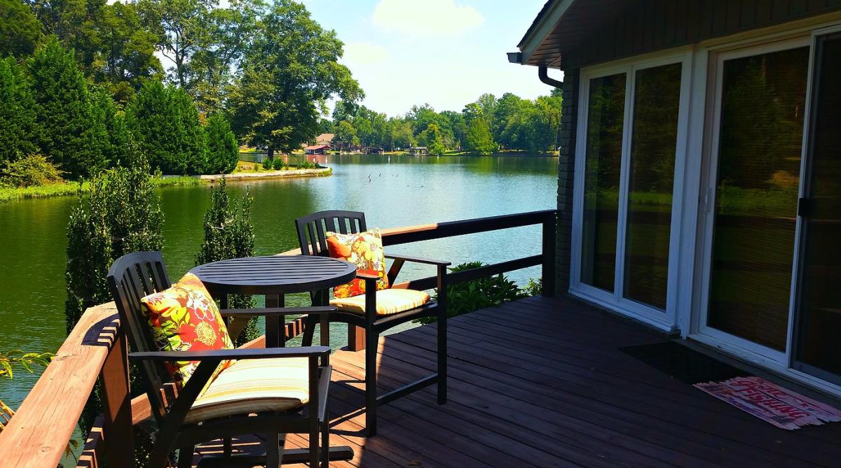 View from the back porch of a cabin overlooking a lake.