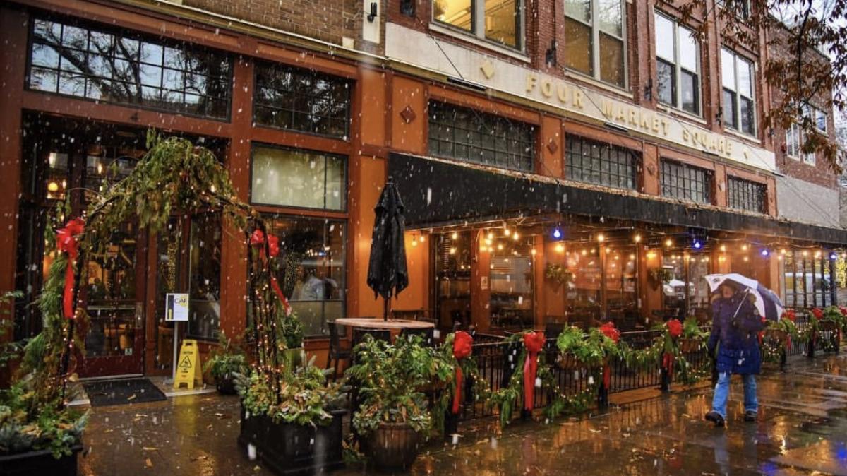 Man walking In Rain Past A Restaurant Patio in Market Square In Knoxville, TN