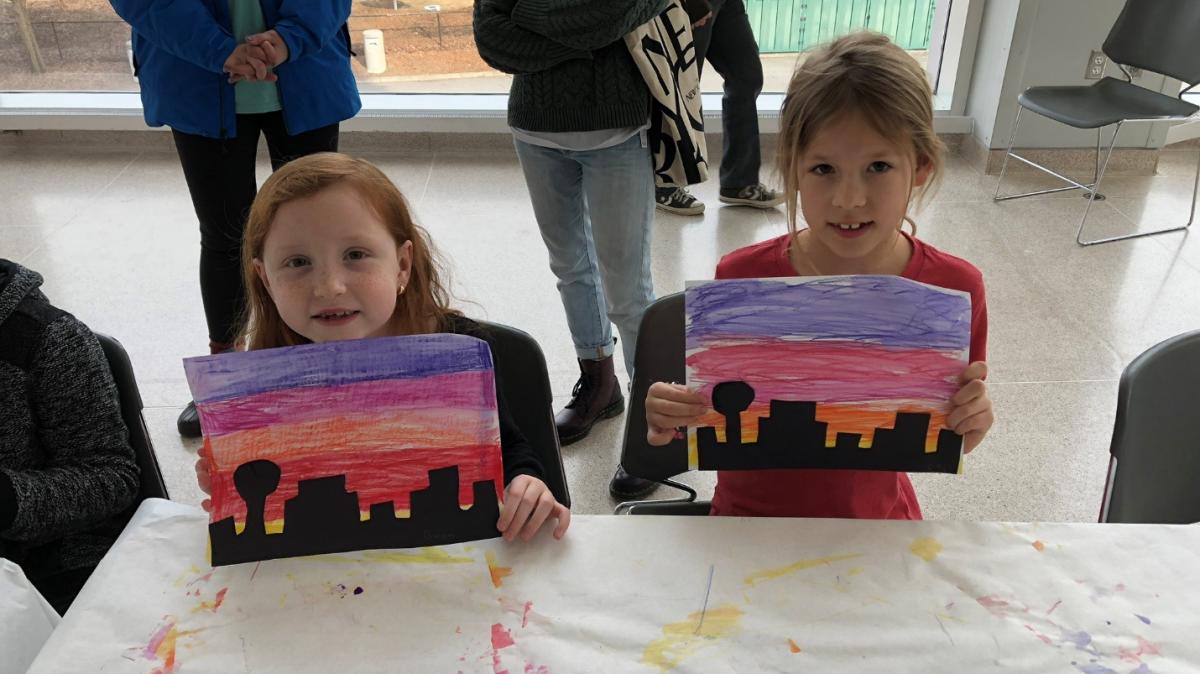 Two girls holding up shadow picture of Knoxville at the Museum of Art