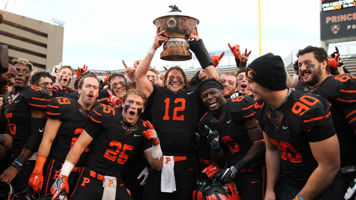 The Princeton Tigers football team holding up a large bowl trophy