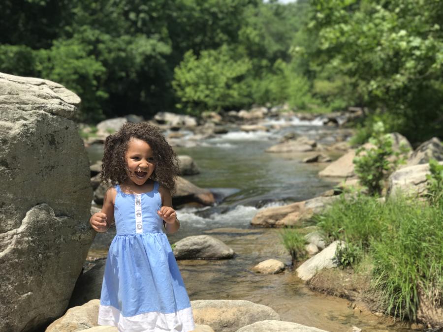 A girl plays along the water's edge of the Rocky Broad Riverwalk in Chimney Rock, NC.