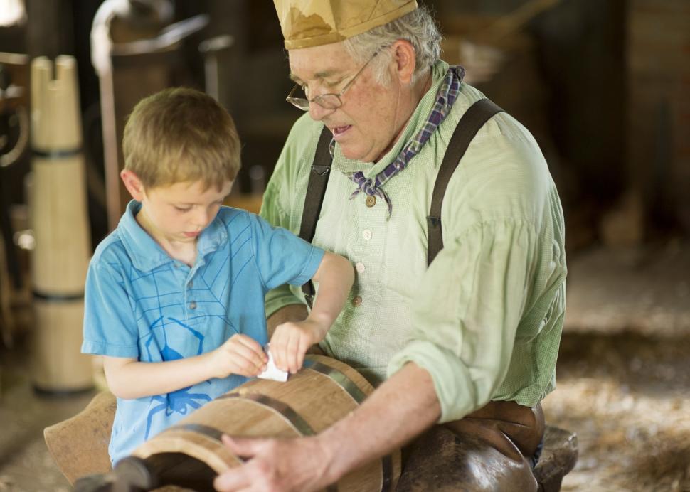 Child helping costumed man at Genesee Country Village & Museum