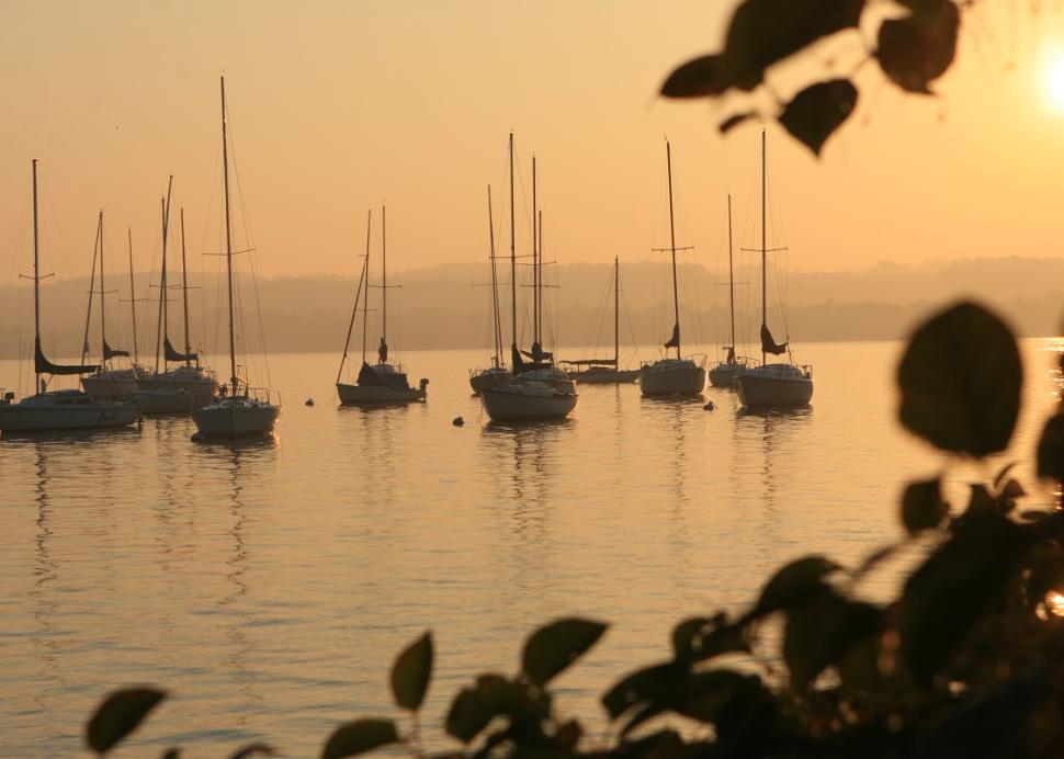 Photo of a sunset overlooking sailboats anchored at a dock on Canandaigua Lake