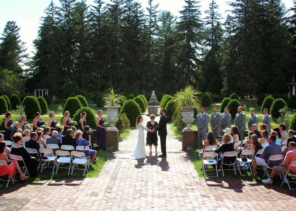 A bride and groom exchange vows during their wedding at Sonnenberg Mansion and Gardens