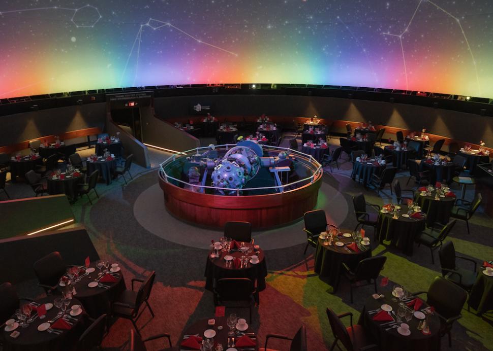 Meeting space with tables and chairs in the planetarium at Rochester Museum & Science Center