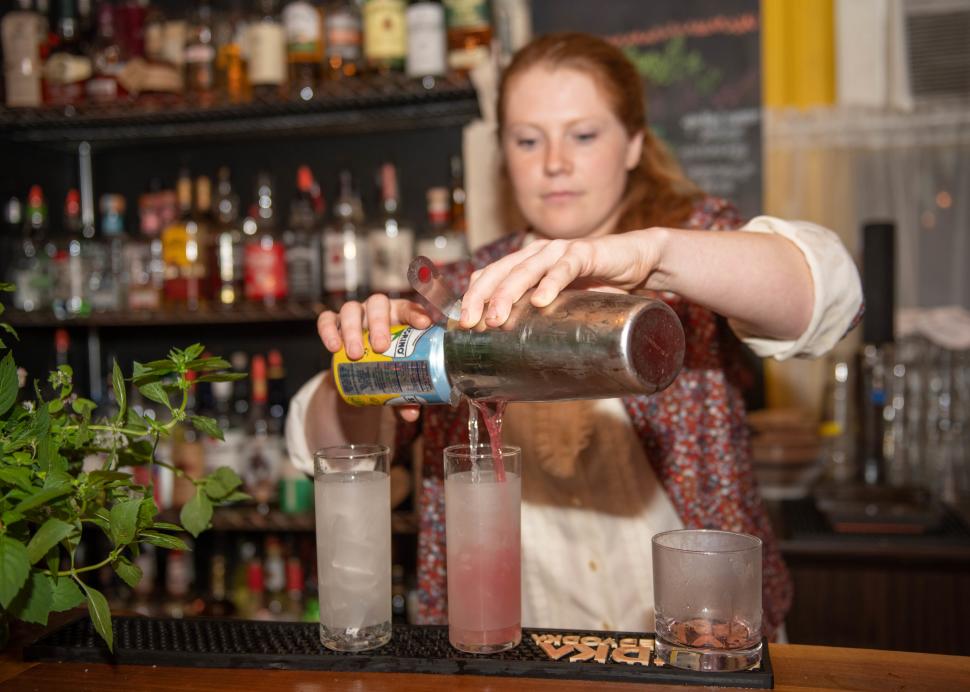 A bartender prepares drinks at Roots Cafe in Naples