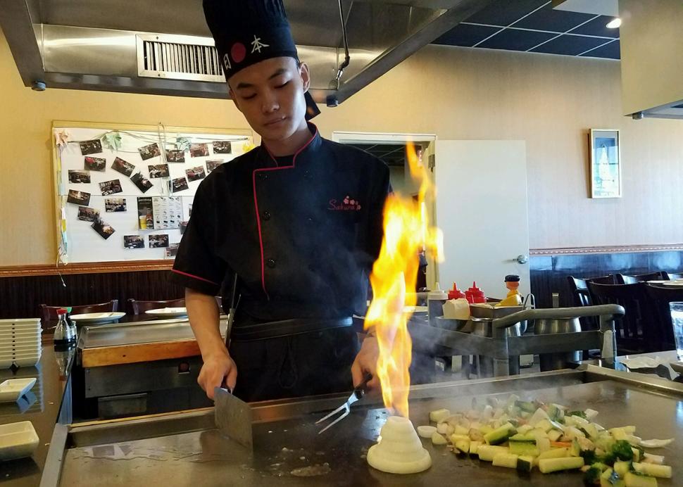 A chef lights a onion ring tower on fire at Sakura Japanese Steakhouse & Sushi Bar in Canandaigua