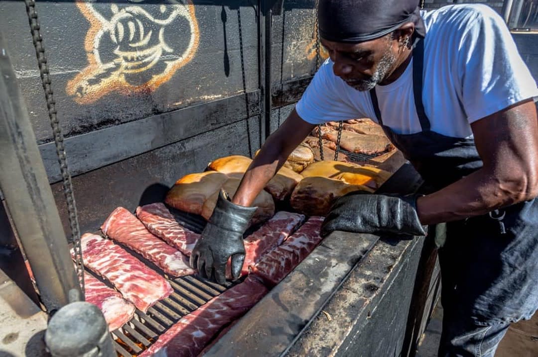 Man Tending to a BBQ Pit in West Alley BBQ Chandler