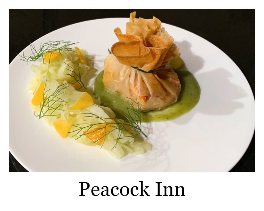 a plated meal from Peacock Inn with vegetables and some kind of bundled main course