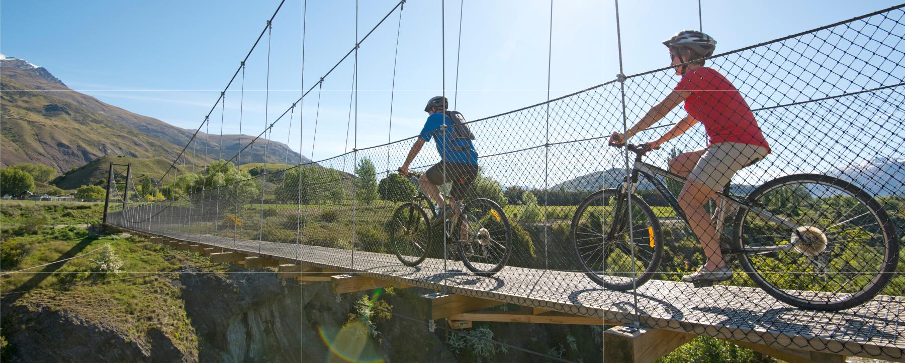 Couple biking over the Edgar Bridge, Gibbston