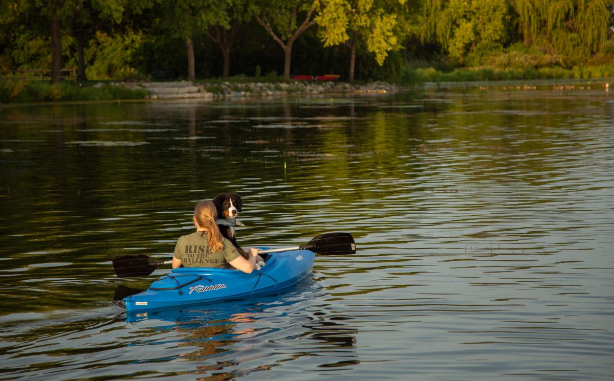 Woman and dog kayaking on Lake Wingra in Madison, WI