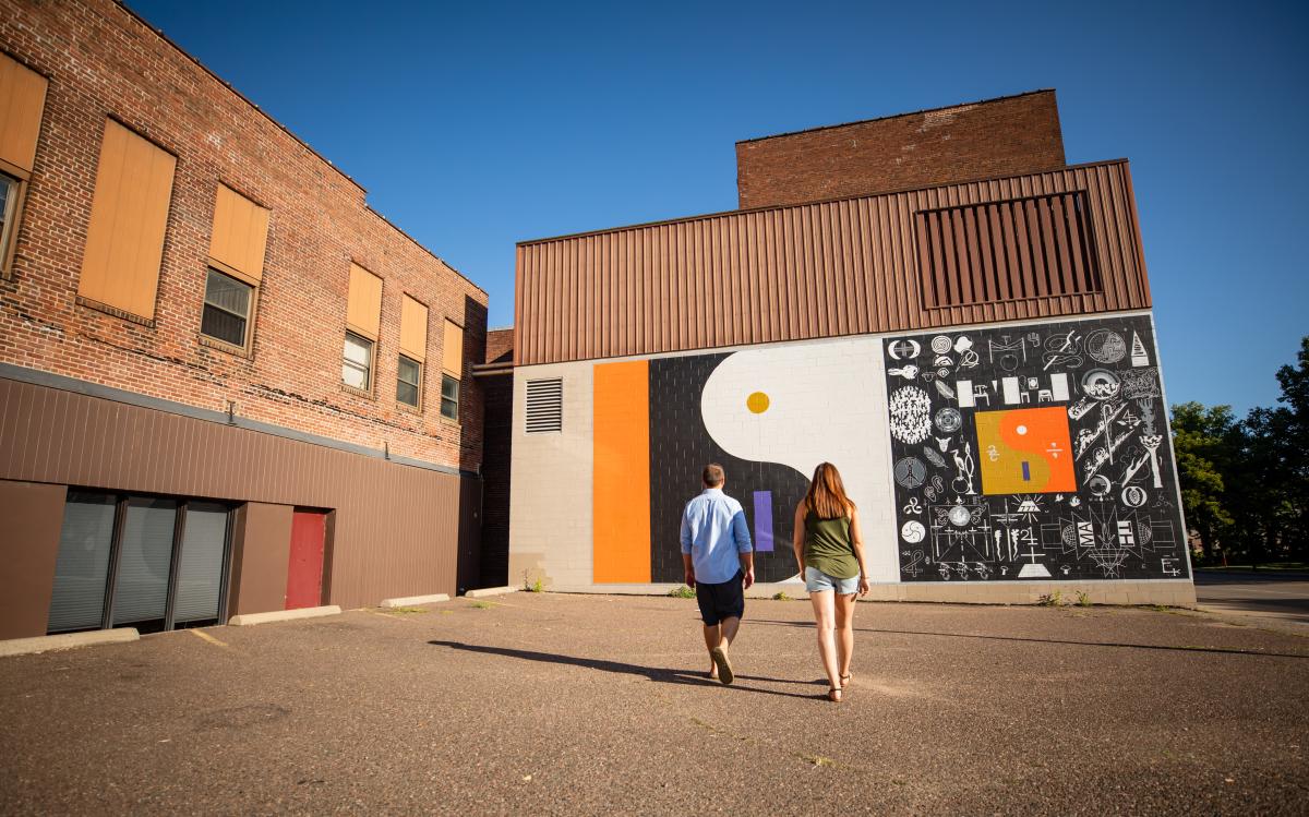 Couple looking at Bon Iver Mural in Downtown Eau Claire