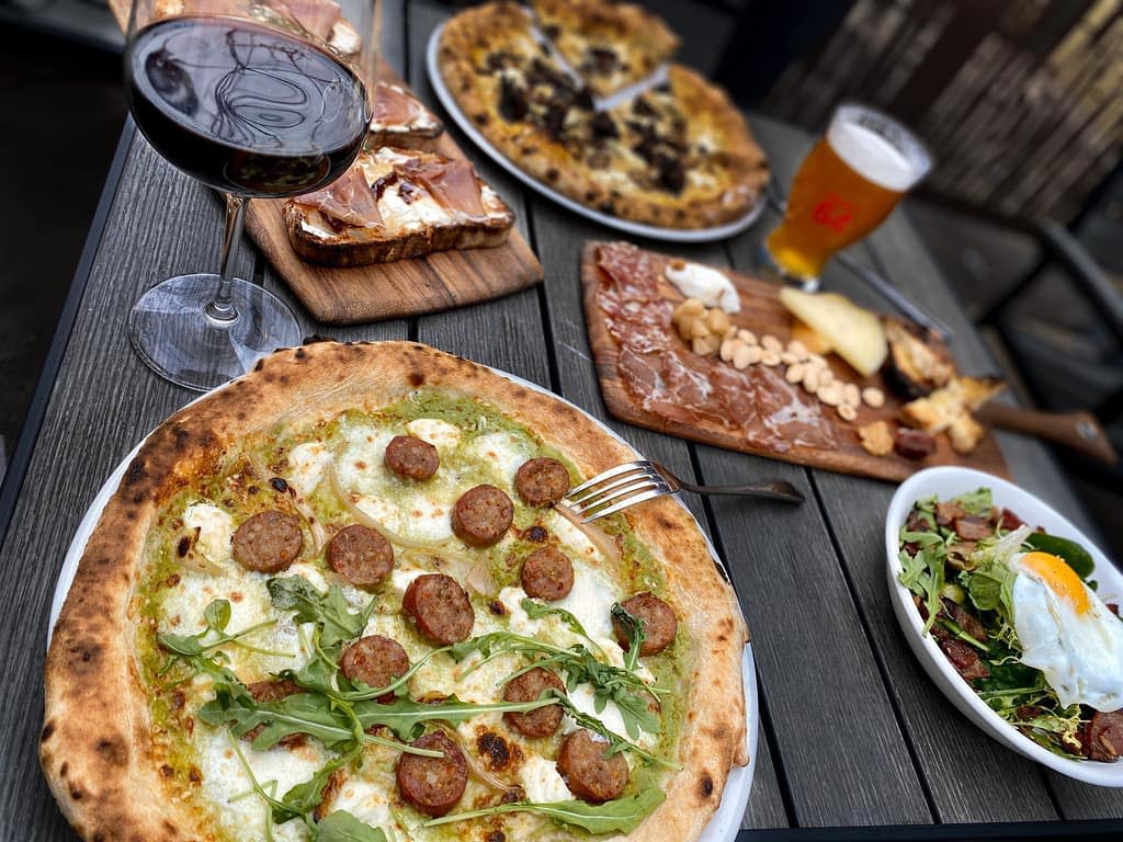 Pizza and wine on an outdoor table at Craft 64 in Chandler, AZ