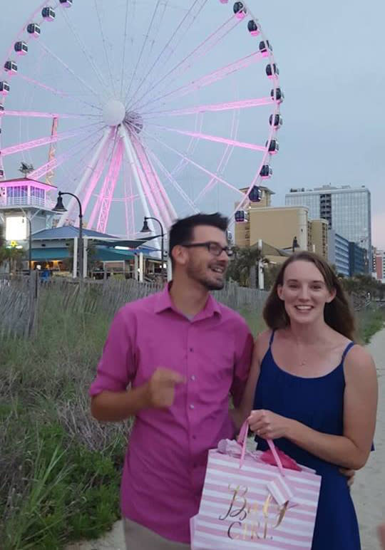 Gender reveal couple in front of pink skywheel