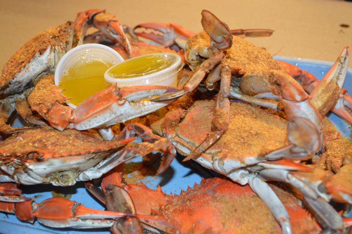 whole crabs with tubs of butter on a platter