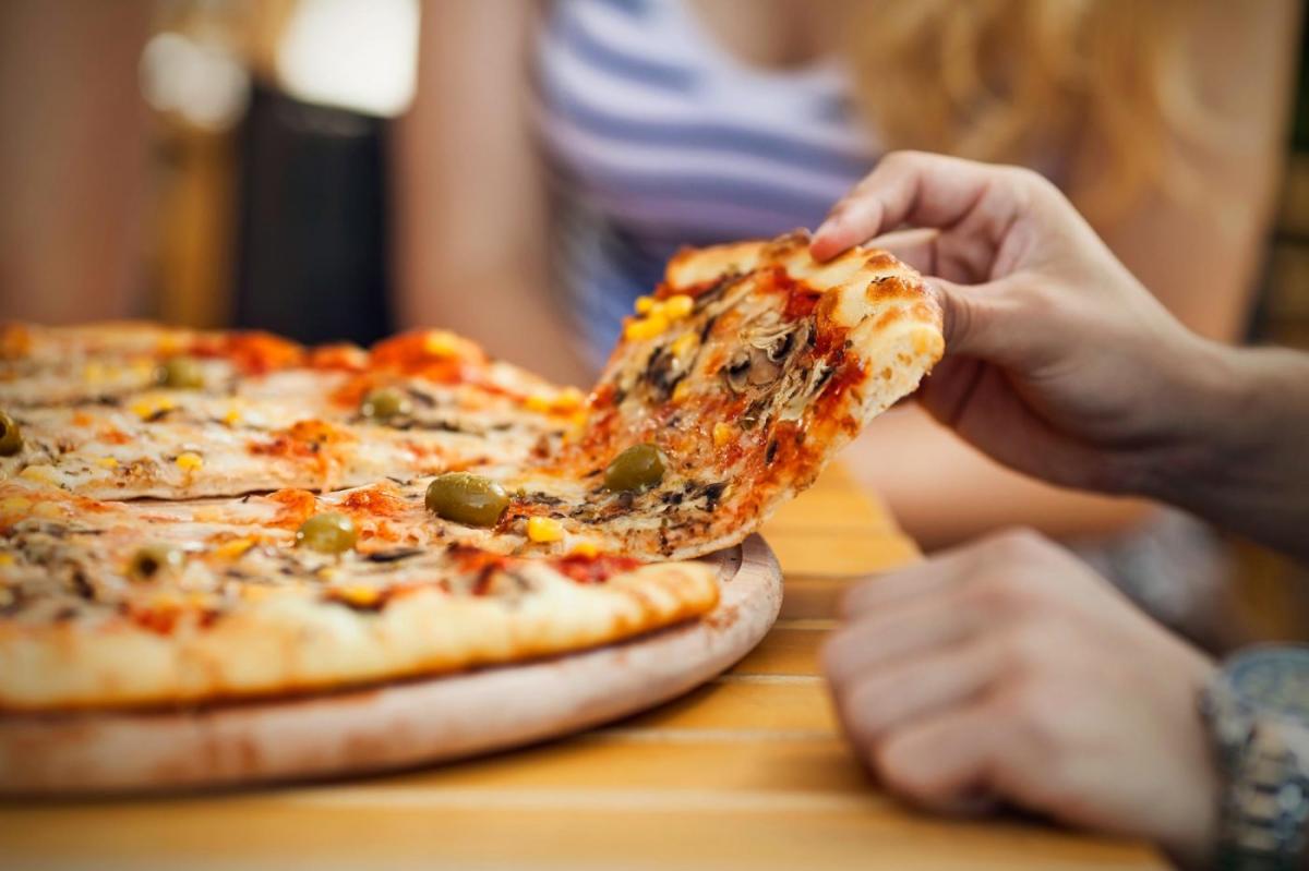 Person Pulling a Slice of Pizza