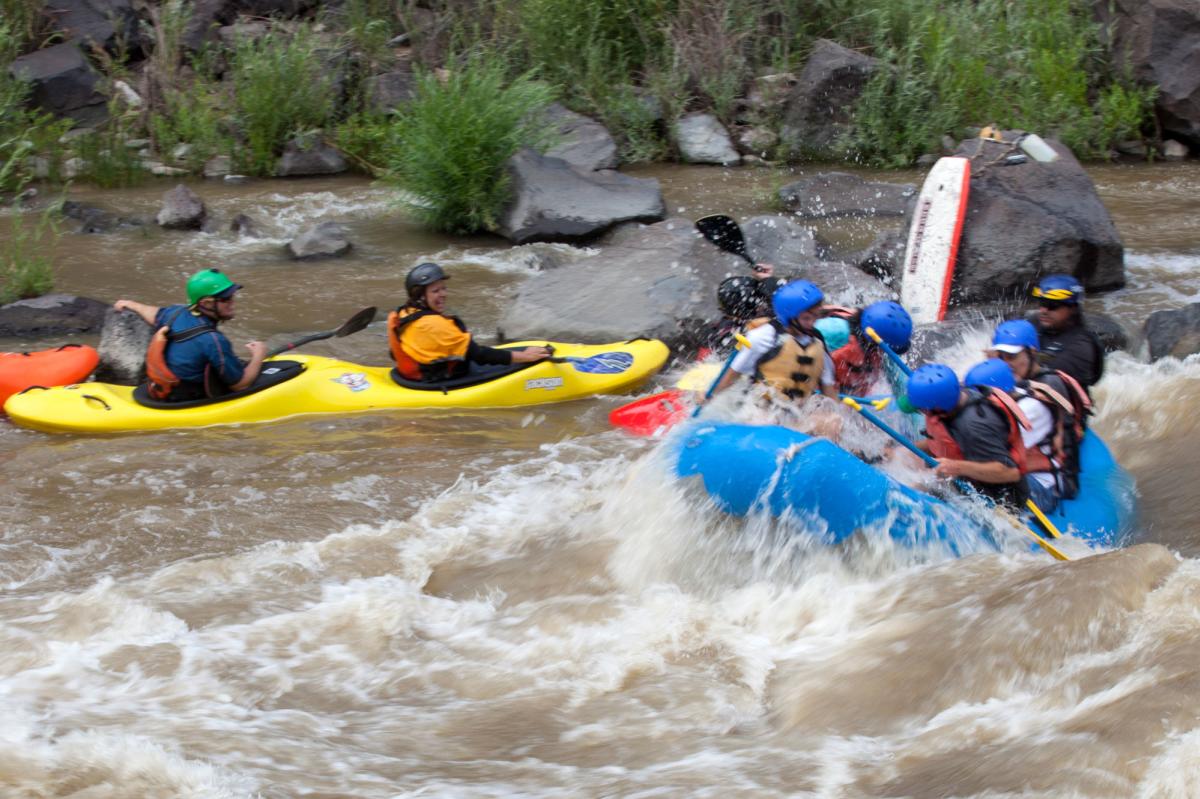 A double kayak and raft navigate the Rio Grande River in New Mexico