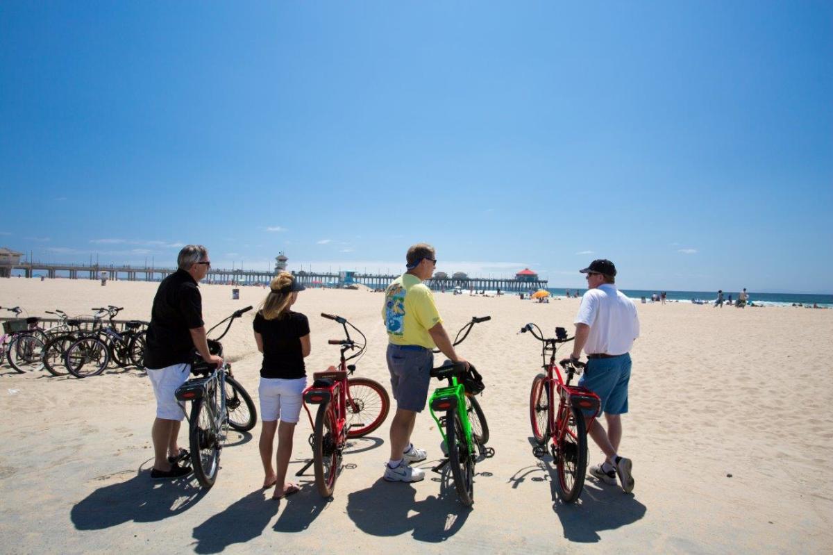 A group of friends standing by their bikes near the beach in Huntington Beach