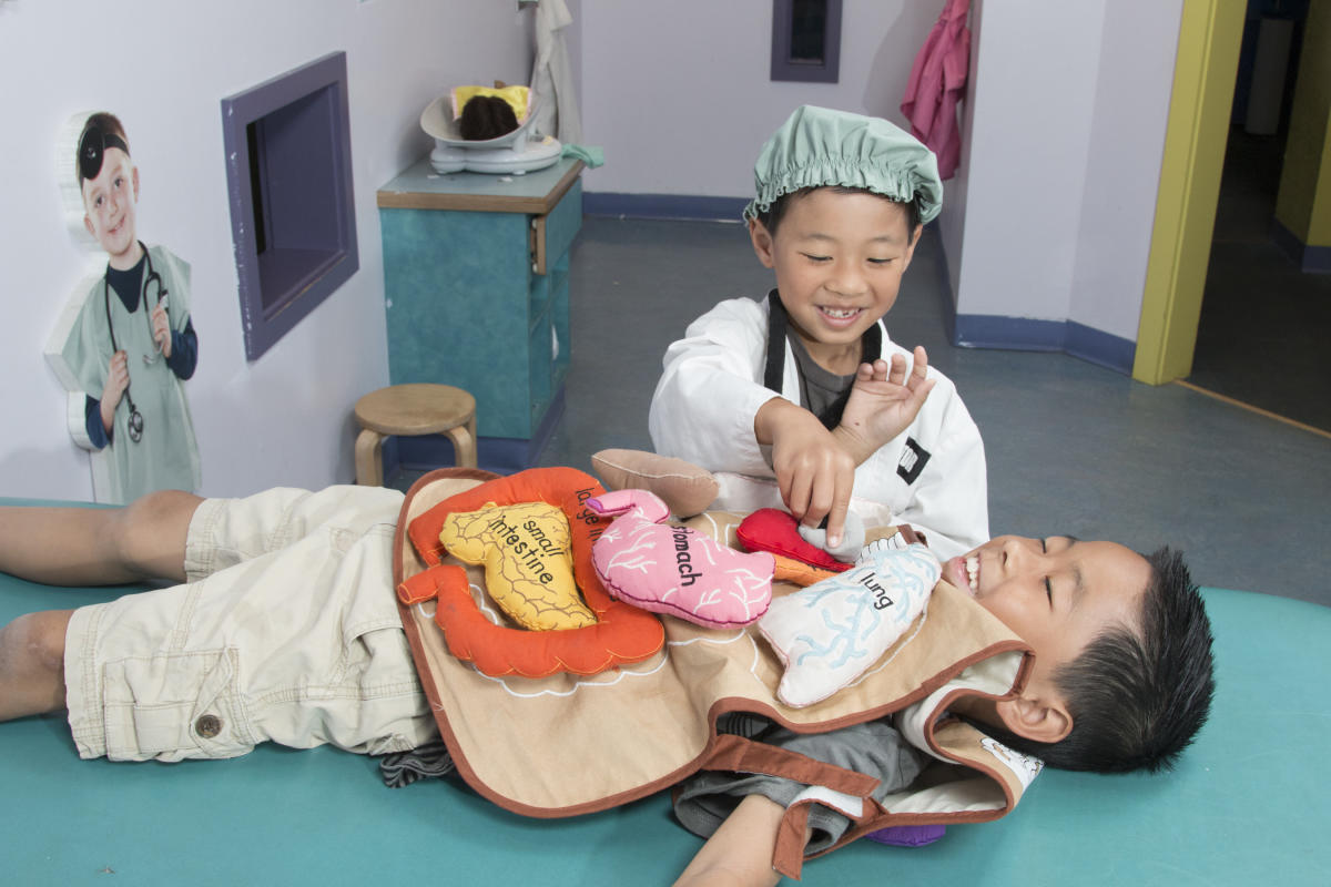 Children playing dress-up as doctor and patient