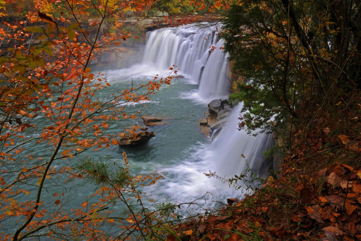 Littler River Falls and river framed by trees with leaves colored orange for fall