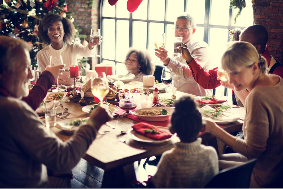 An extended, mixed family cheersing around a festive table