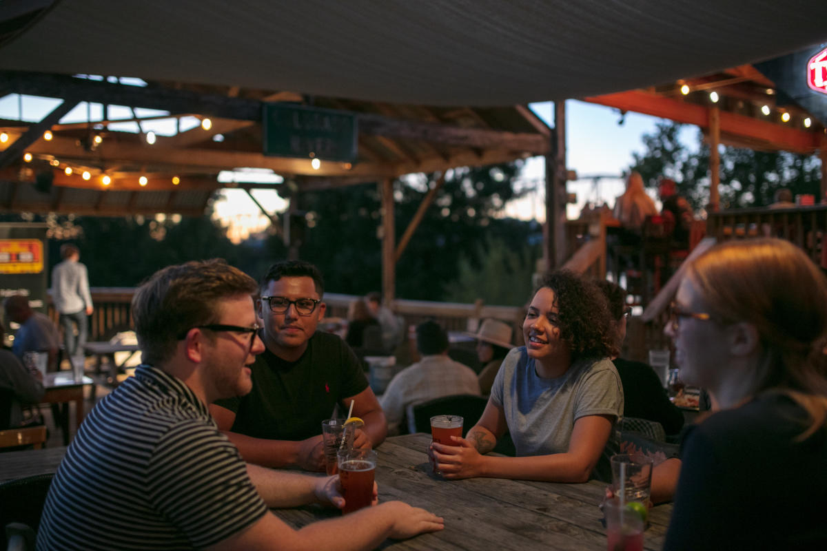 Three people sitting at table on patio 