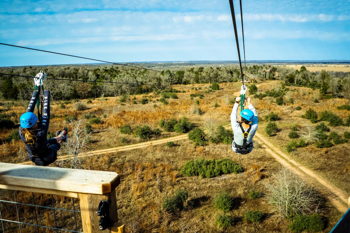 Man and woman zip lining in Lost Pines