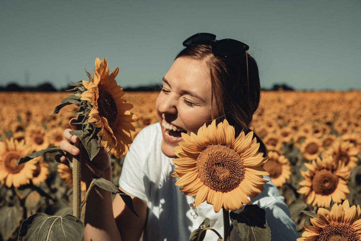 Laughing in a field of sunflowers at Babbette's Seeds of Hope