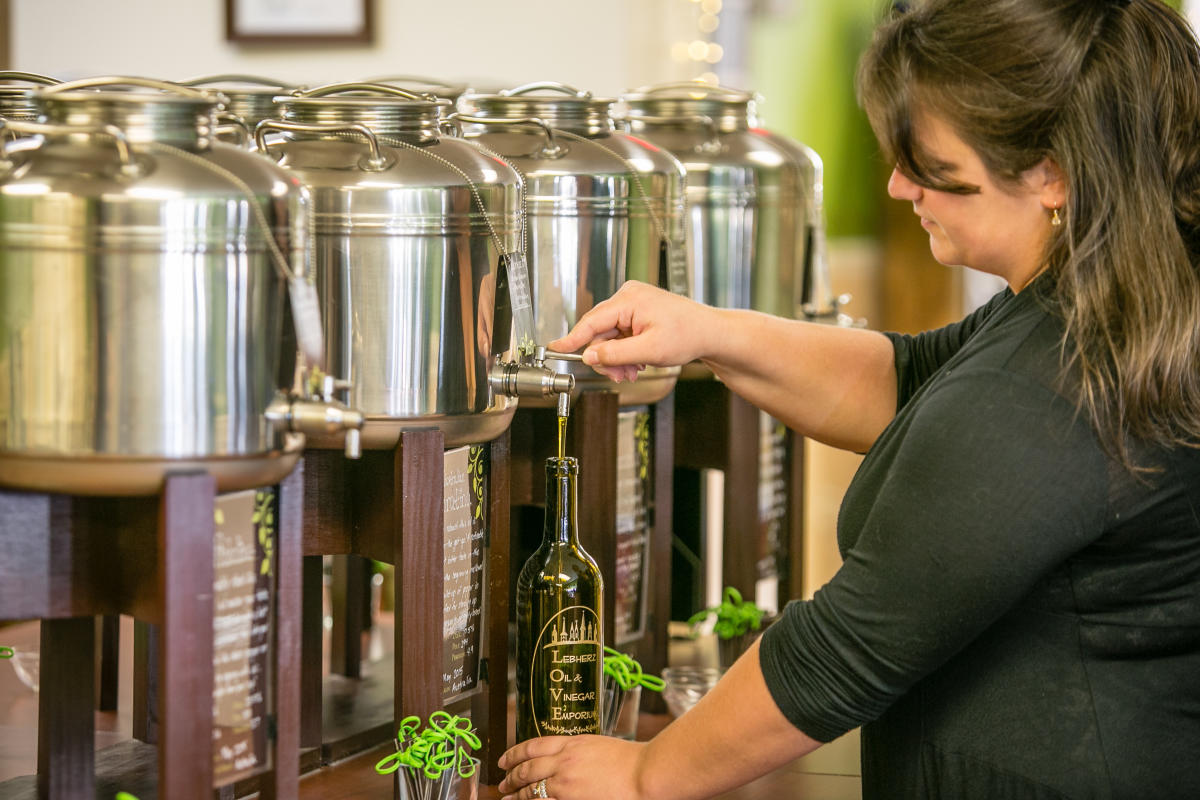 Woman filling a bottle of olive oil from Oil & Vinegar