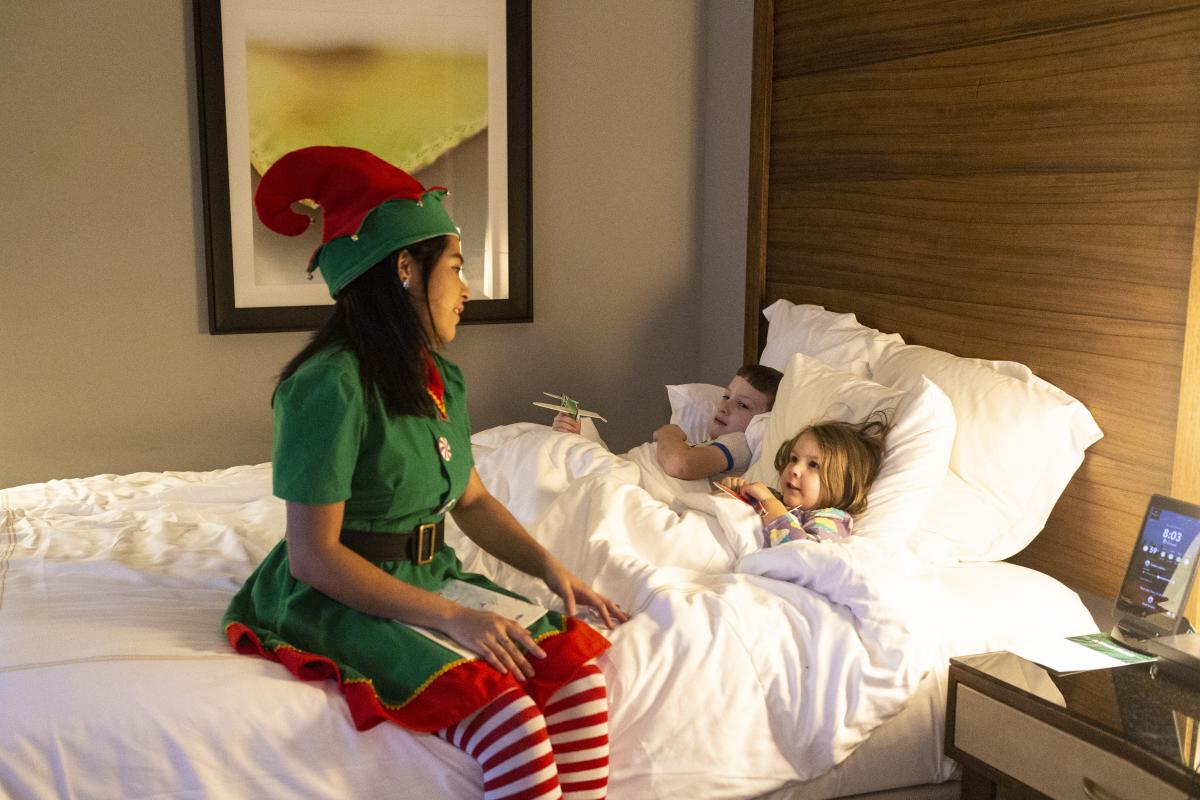 An Elf Hostess tucks children in at The Woodlands Resort