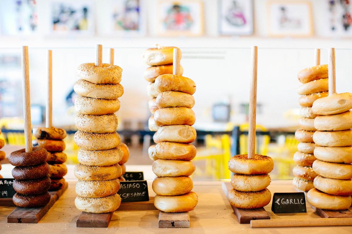 Different types of bagels stacked high on rods at Great Bagel and Bakery.