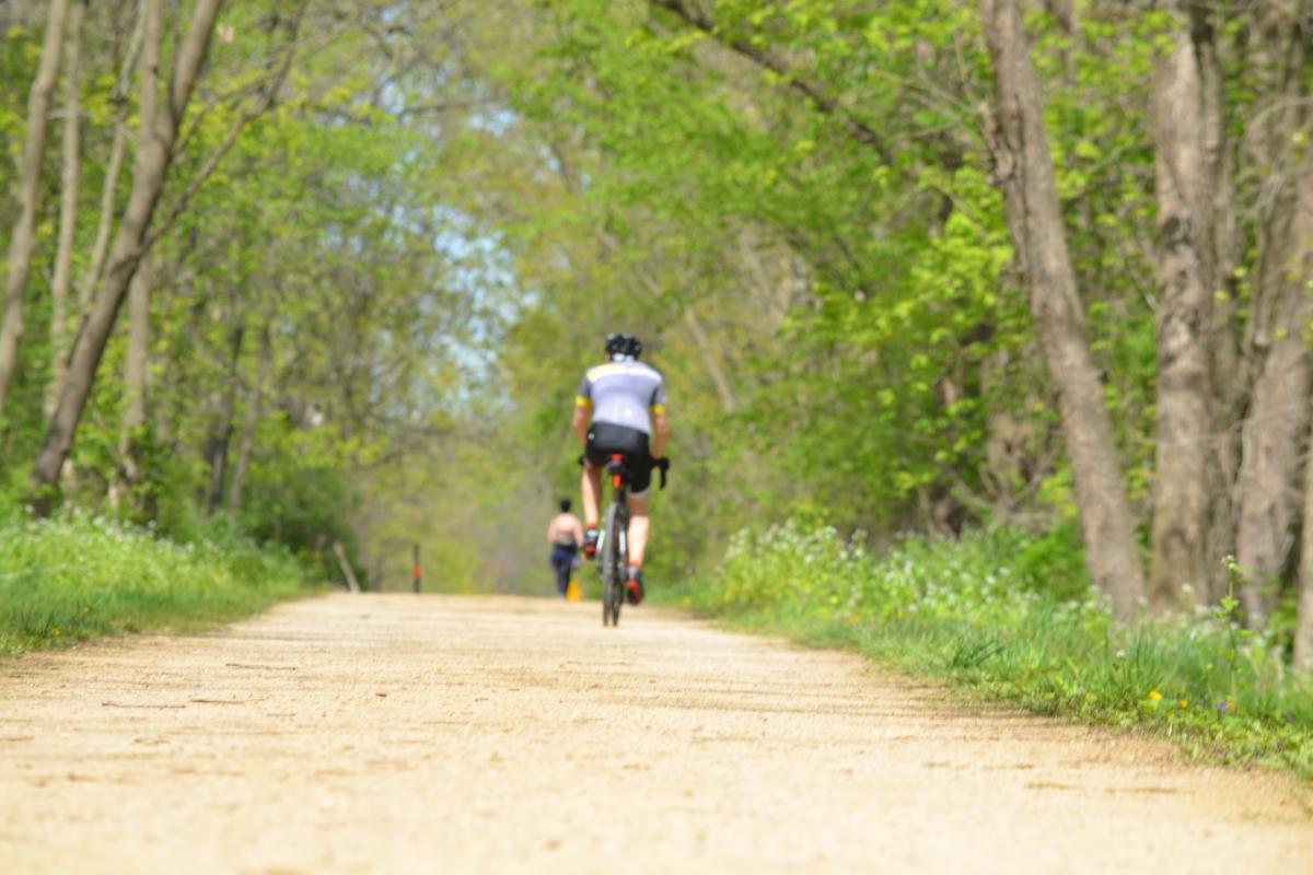 A biker rides on a gravel portion of the Military Ridge State Trail