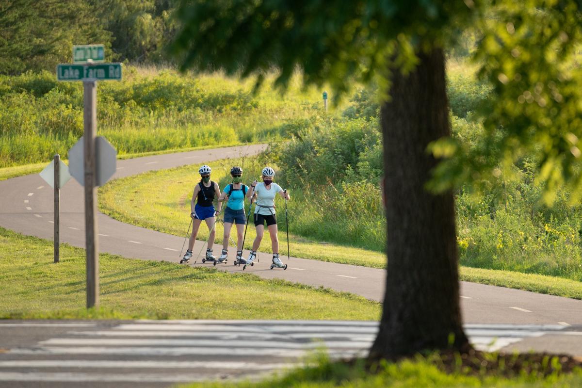 Three people roller ski on the Lower Yahara River Trail