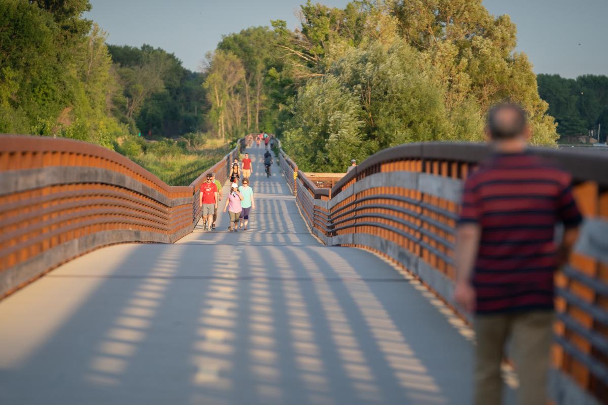People walk the Lower Yahara River Trail bridge over Lake Waubesa