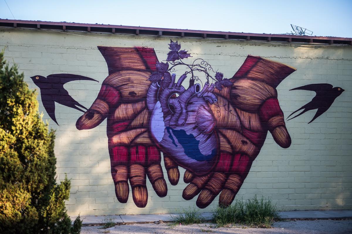 Mural of two hands holding a purple heart