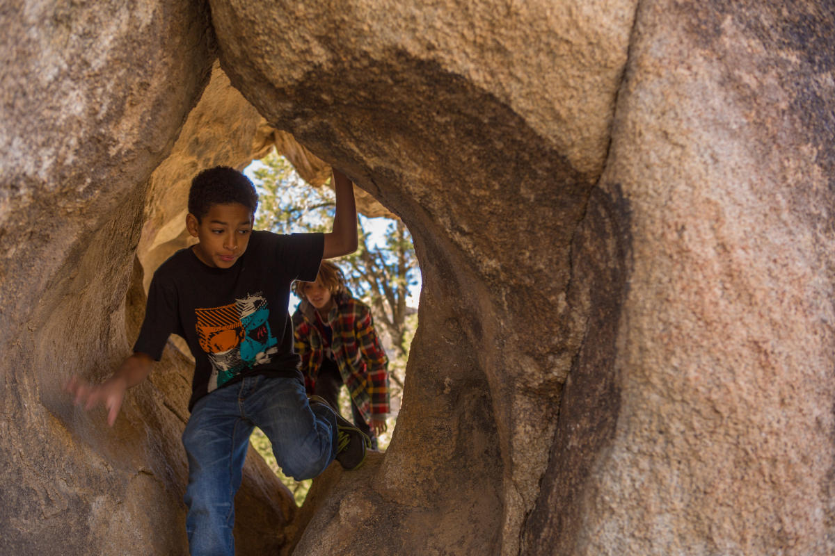 Youth hike through a rock formation during a Desert Adventures Tours outing.