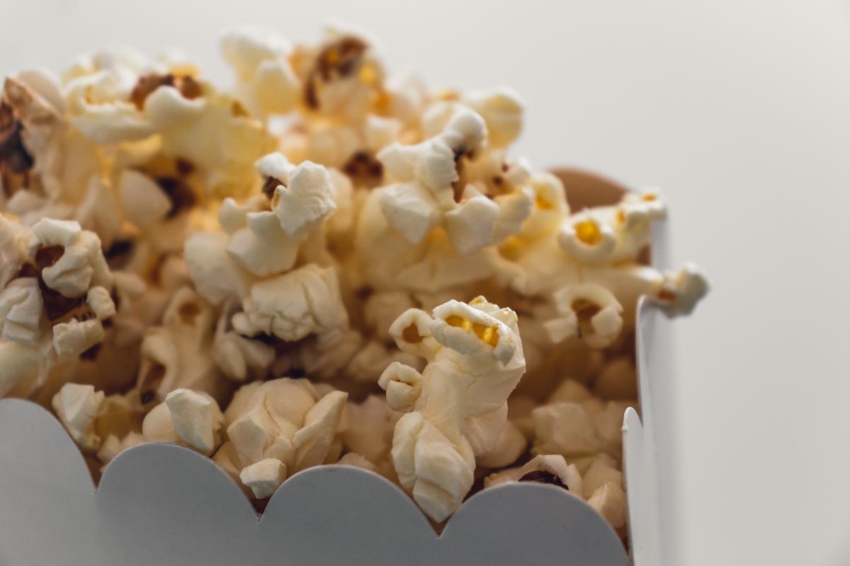 A white cardboard container filled with popcorn.