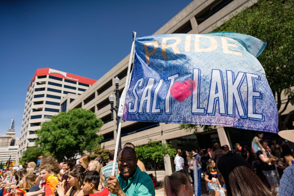 Man holding Pride Salt Lake Flag