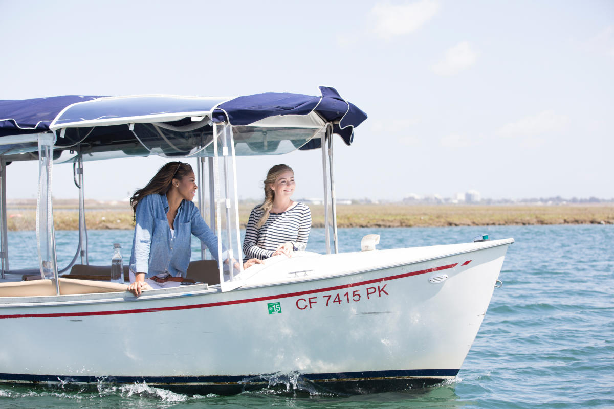 Two women cruising on a motor boat in Huntington Harbour