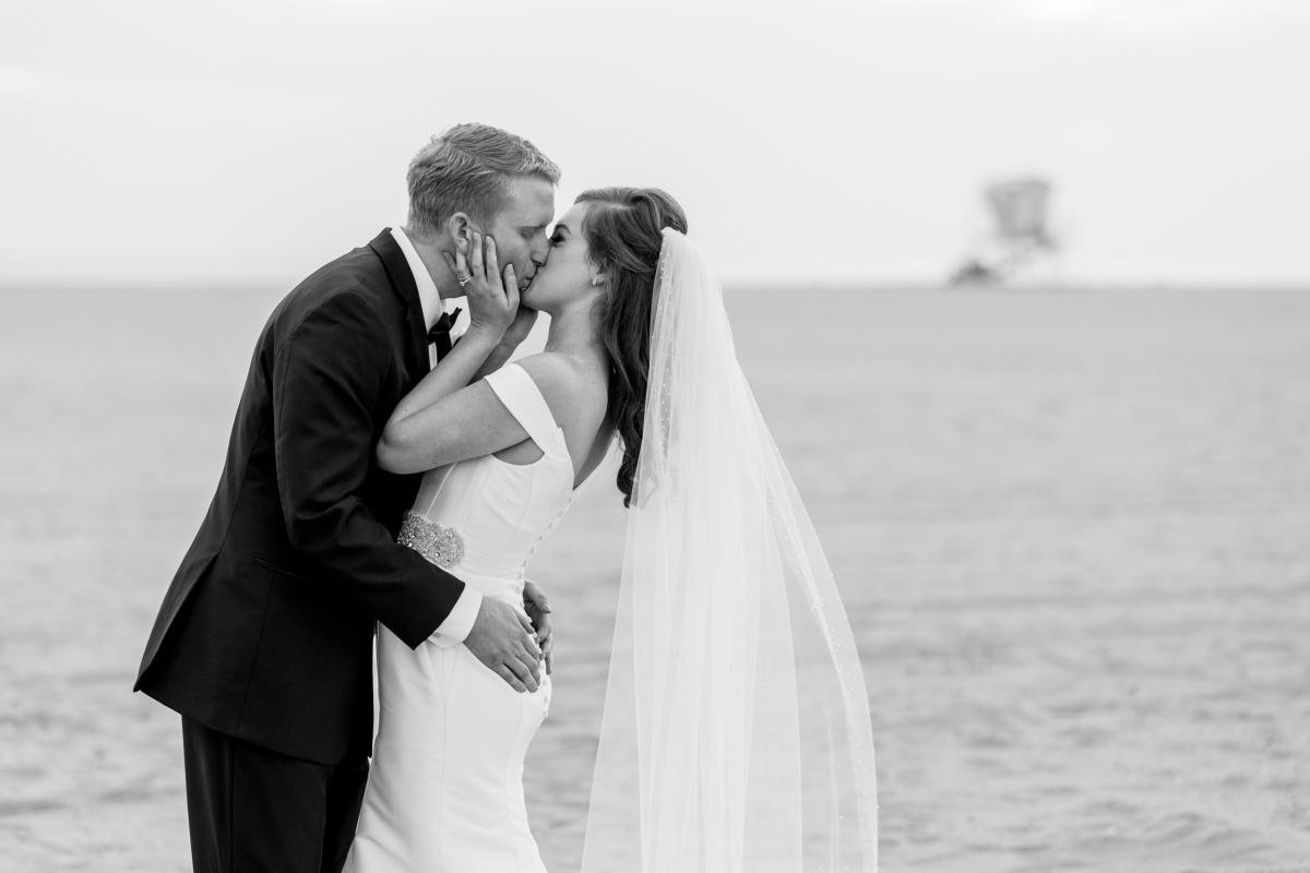 Newlyweds kissing on the beach in Huntington Beach