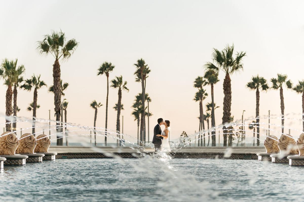 Newlyweds kissing at the Hyatt Regency Resort & Spa wedding venue in Huntington Beach