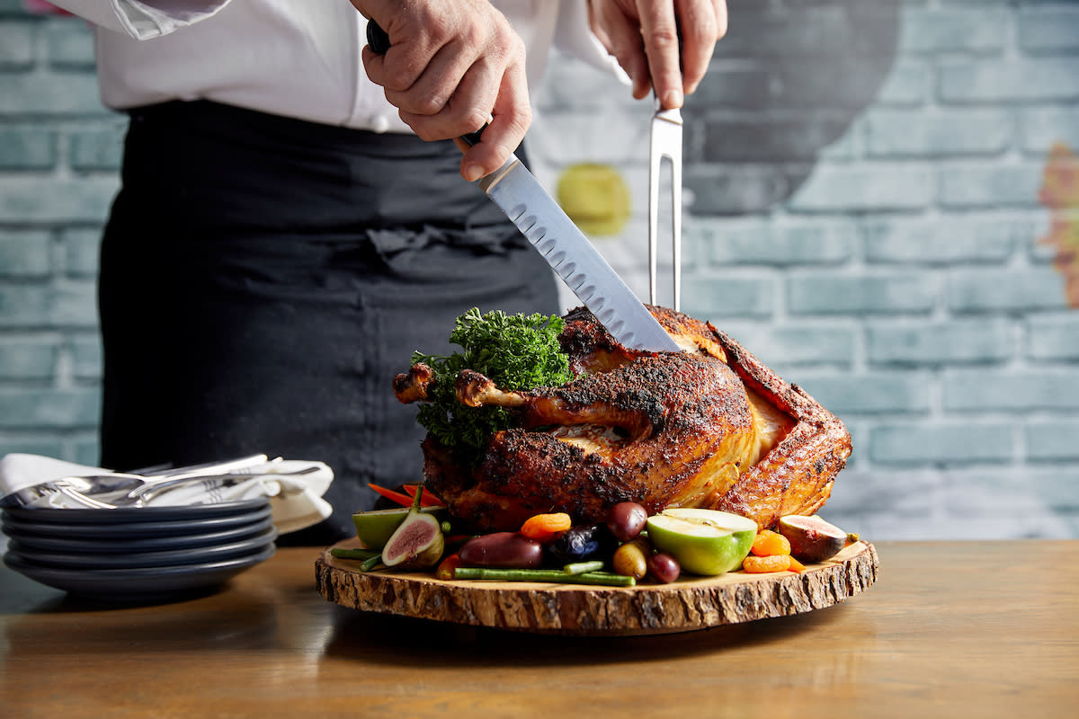 A member of the waitstaff prepared to carve a Thanksgiving dinner turkey at Pacific Hideaway.