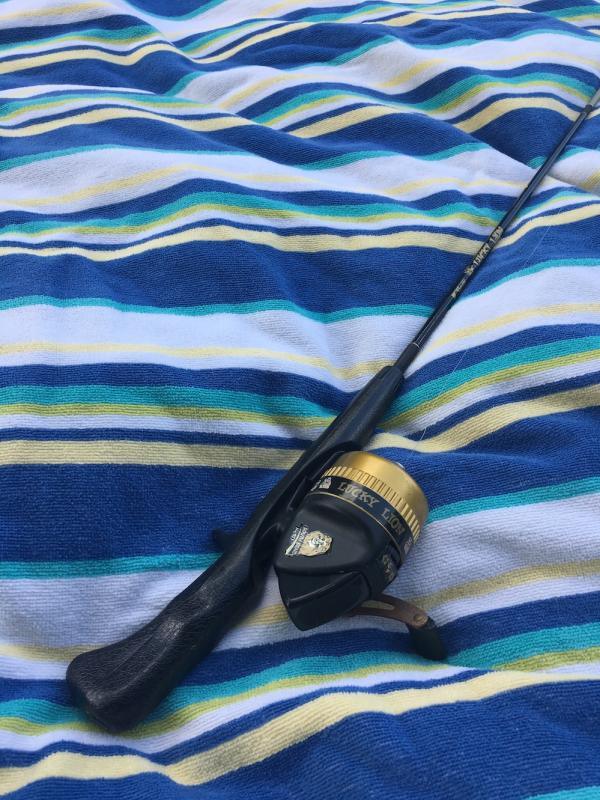 Fishing pole on beach towel for day trip to Big Falls
