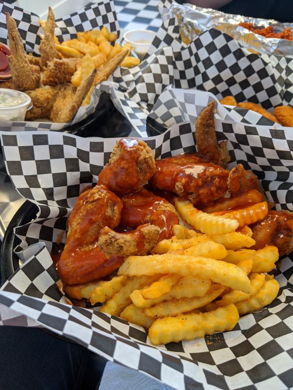 Close up of chicken wings and french fries