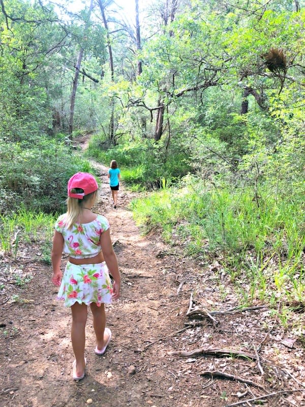 Kids walking through path in woods