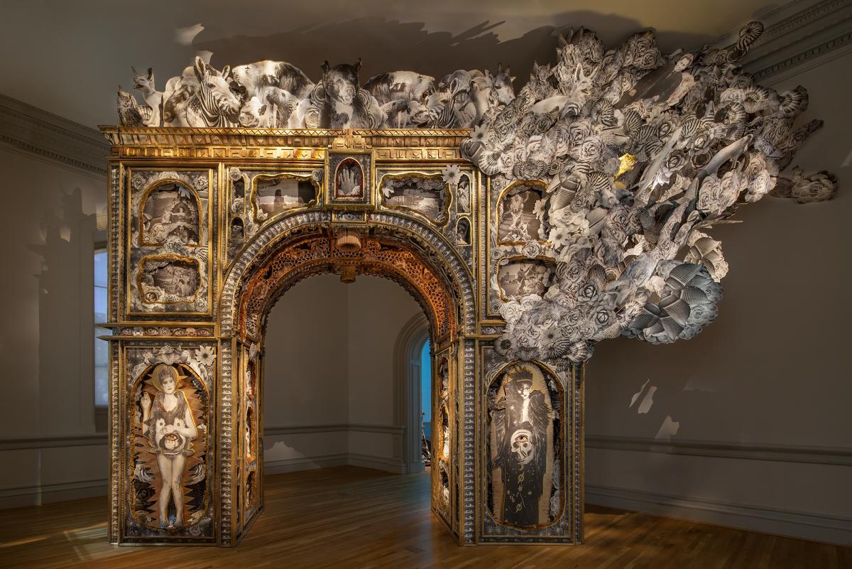 A freestanding arch that looks like the Arch de Triomphe from Burning Man made of Paper