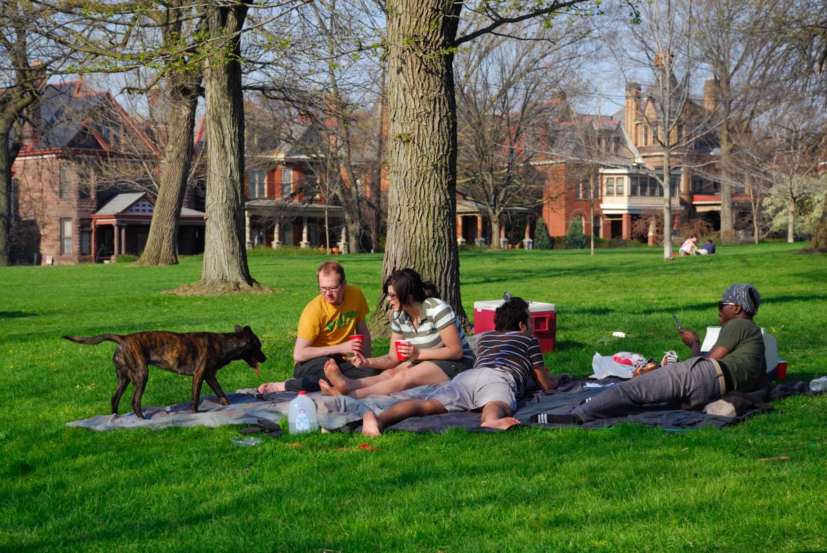 A group of four friends (and a dog) enjoys a picnic in Goodale Park