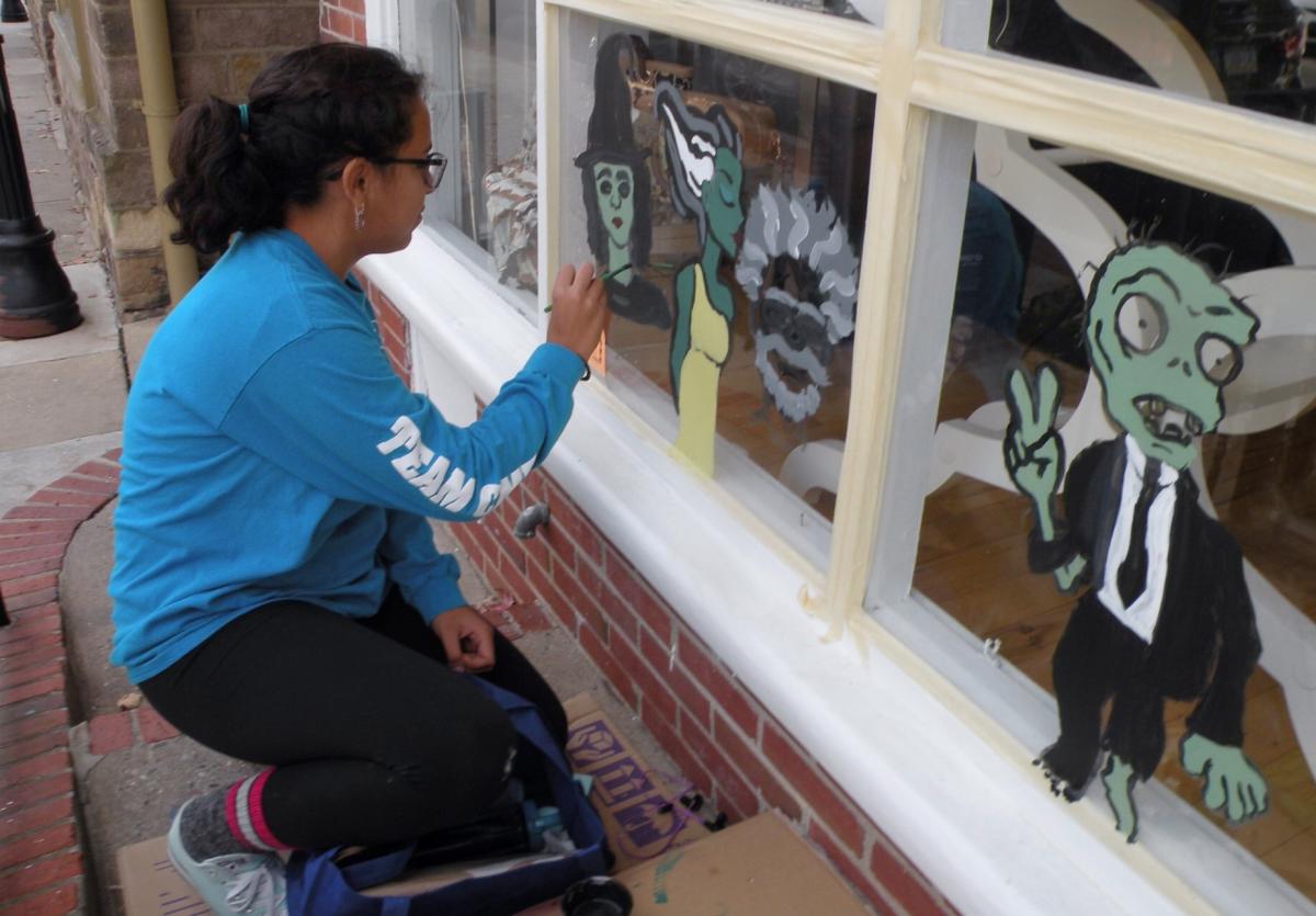Woman painting Newtown window