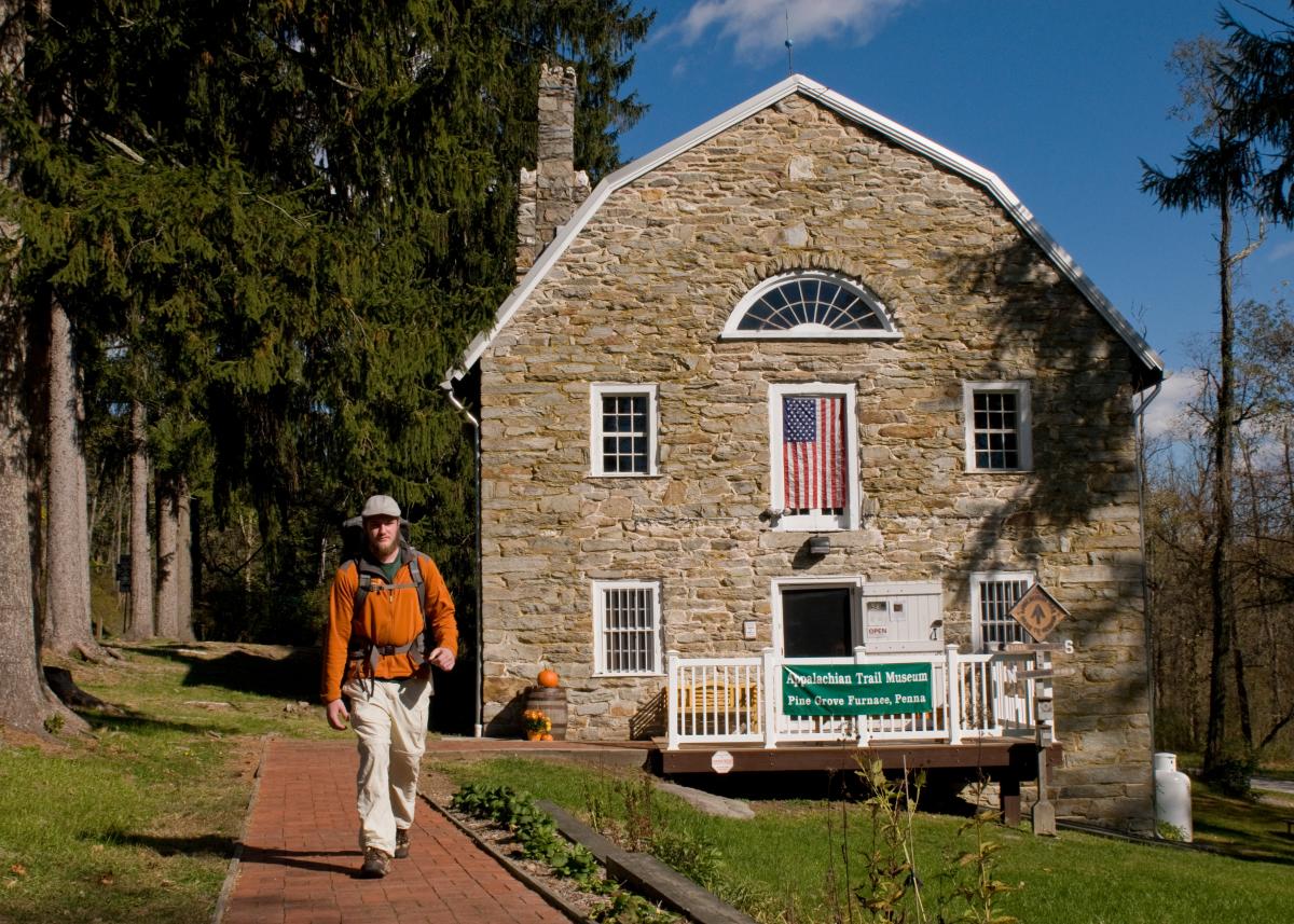 A hiker walks past the Appalachian Trail Museum, located along the A.T.